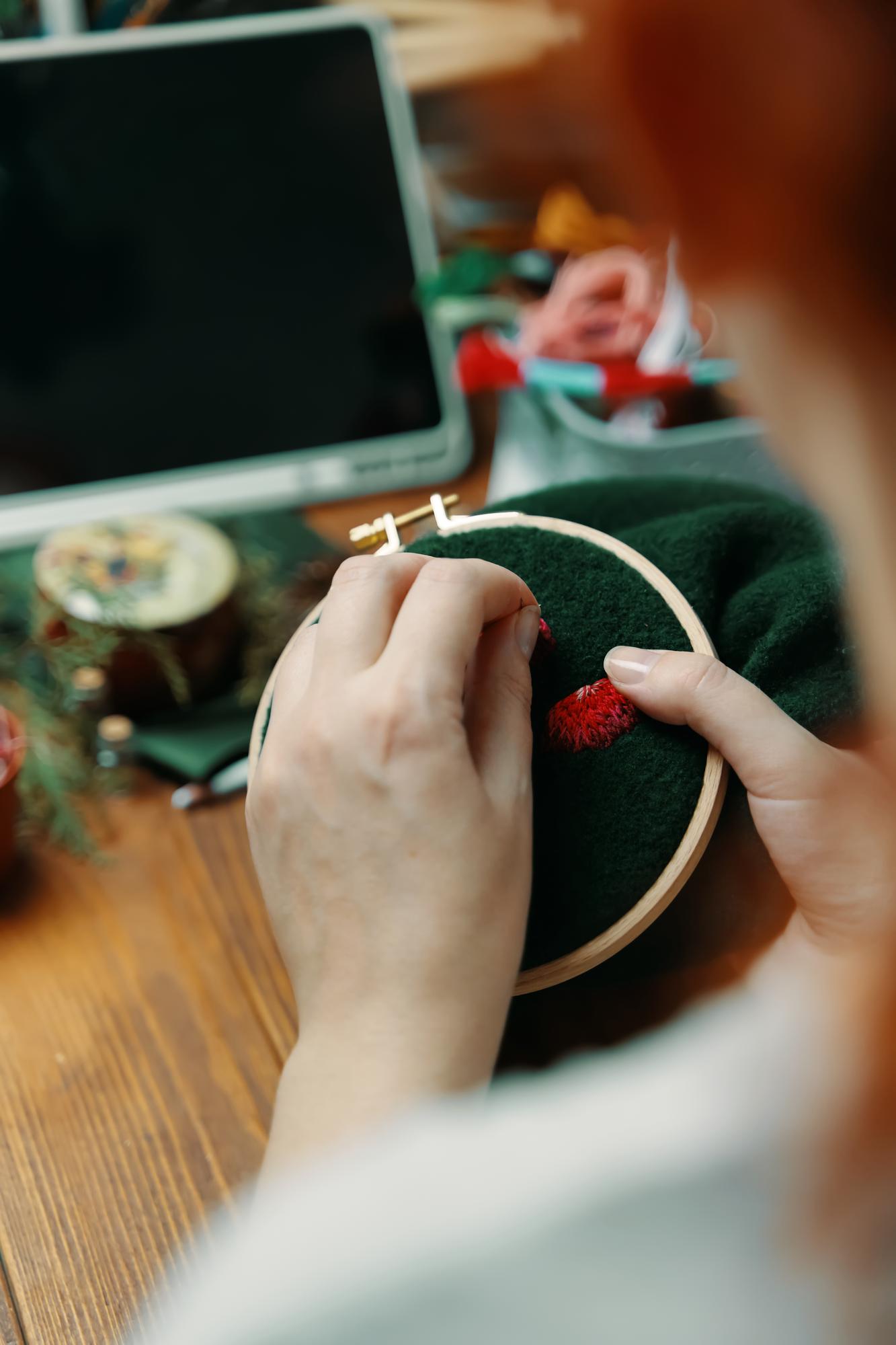 atelier hands embroidering gold thread